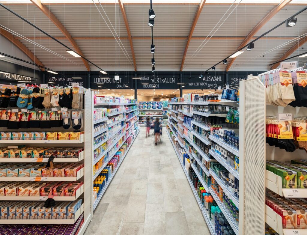 Butiksgång belyst av svart skena med riktbara spotlights i takets mitt som ger jämn, energieffektiv och säljdrivande belysning för hyllor och produkter, kvalitetsarmaturer från PROLJUS AB