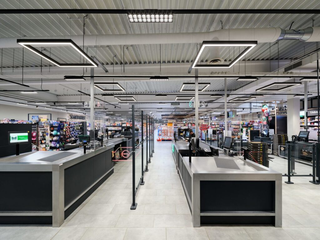 Modern butikskassalinje upplyst av kvadratiska hängande LED-armaturer, jämn och bländfri ljussättning och energieffektiva stilrena lösningar från PROLJUS AB som lyfter varuexponering och kundupplevelse