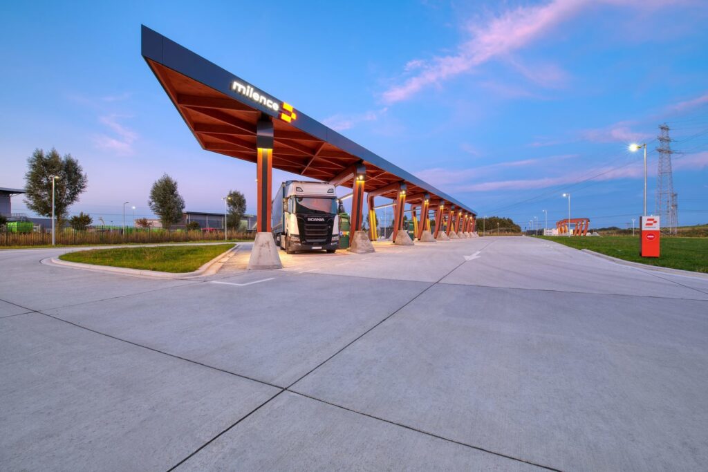 Modern lastbilsstation med ett långt tak där PROLJUS ABs varma, energieffektiva LED-armaturer i taket och på pelarna jämnt lyser upp körfältet och framhäver trygg, kostnadseffektiv nattbelysning för industrimiljöer