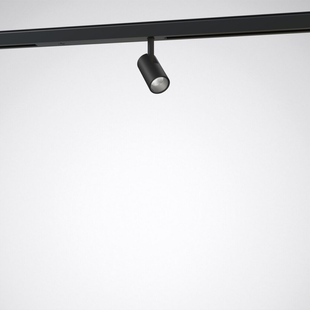 Svart cylinderformad skenspott från PROLJUS AB monterad i takskenssystem, riktbar LED med elegant design, energisnål och hög ljuskvalitet idealisk för butiker, gallerier och moderna hem
