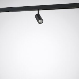 Svart cylinderformad skenspott från PROLJUS AB monterad i takskenssystem, riktbar LED med elegant design, energisnål och hög ljuskvalitet idealisk för butiker, gallerier och moderna hem