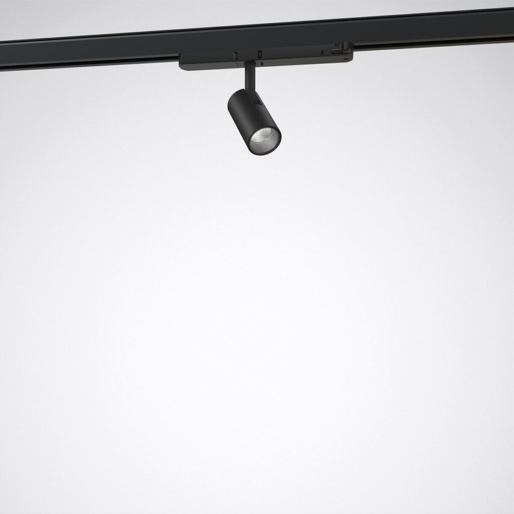 Svart cylinderformad LED-spot från PROLJUS AB monterad i takets skena med justerbar arm och fokuserat högkvalitetsljus perfekt för butik, galleri och modern inredning