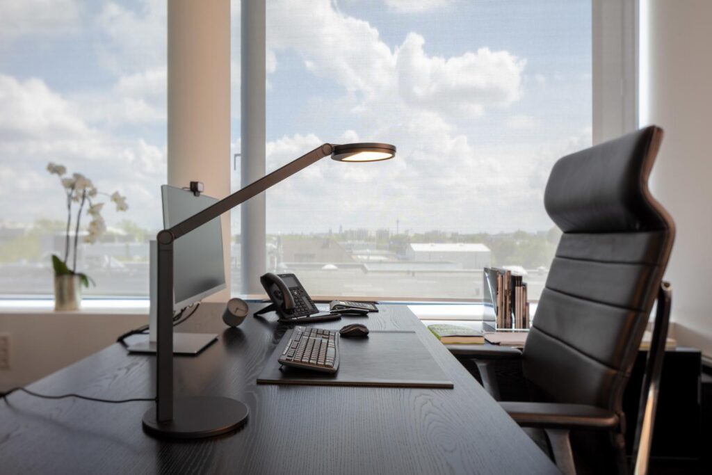 Stilren ställbar LED-skrivbordslampa från PROLJUS AB med tunn rund ljuskälla och varm jämn belysning som lyfter kontoret, spar energi och förbättrar arbetskomforten