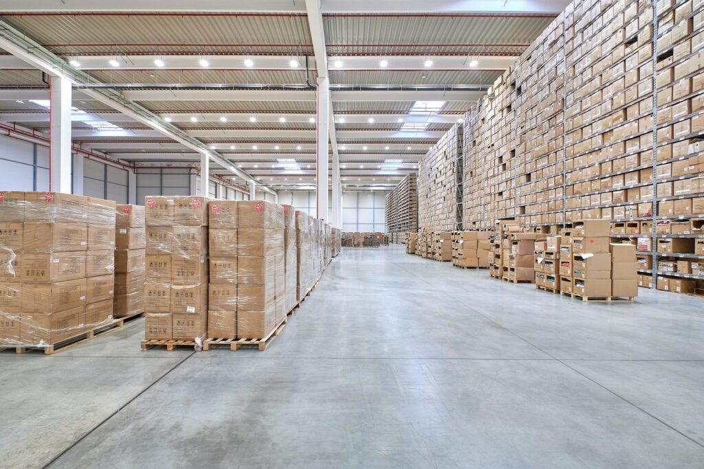 Väl upplyst modernt lager med radvis monterade energieffektiva LED-takarmaturer som ger jämnt och klart ljus över höga hyllor och stora golvytor, en demonstration av belysningslösningar från PROLJUS AB som förbättrar sikt, säkerhet och minskar energikostnader