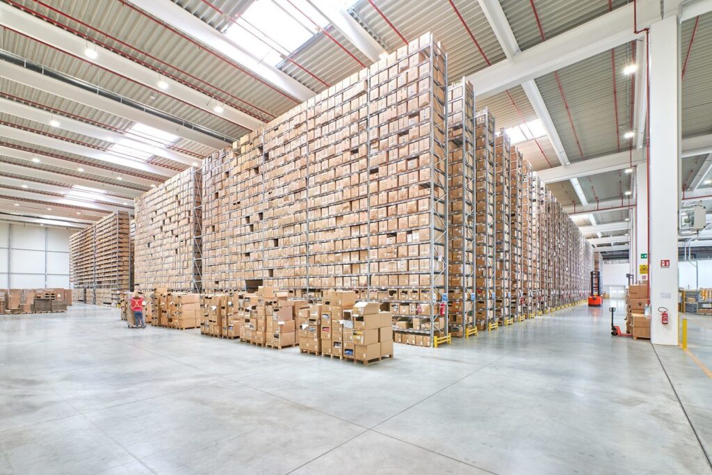 Stort lager upplyst av PROLJUS ABs ljusstarka, energieffektiva LED-armaturer som ger jämn, bländfri belysning genom hela lokalen mellan höga hyllrader och takfönster och ökar säkerhet samt produktivitet