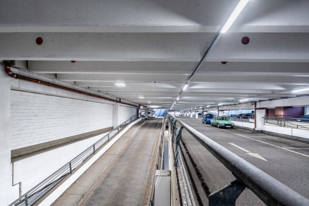 Välbelyst flervåningsgarage med moderna LED-armaturer från PROLJUS AB som ger jämnt, energieffektivt ljus för trygga parkeringsmiljöer