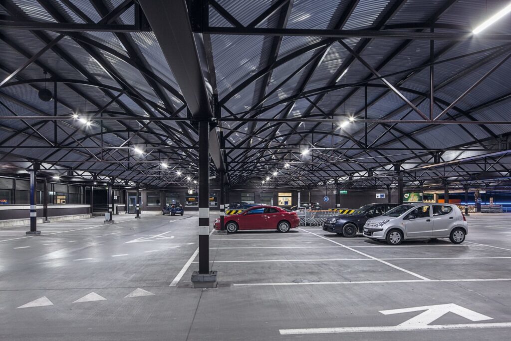 Takbelyst parkeringsgarage med PROLJUS ABs energieffektiva LED-armaturer monterade på stålbalkar, jämnt och starkt ljus som framhäver parkeringsrutor, ökar säkerheten och minskar driftkostnaderna