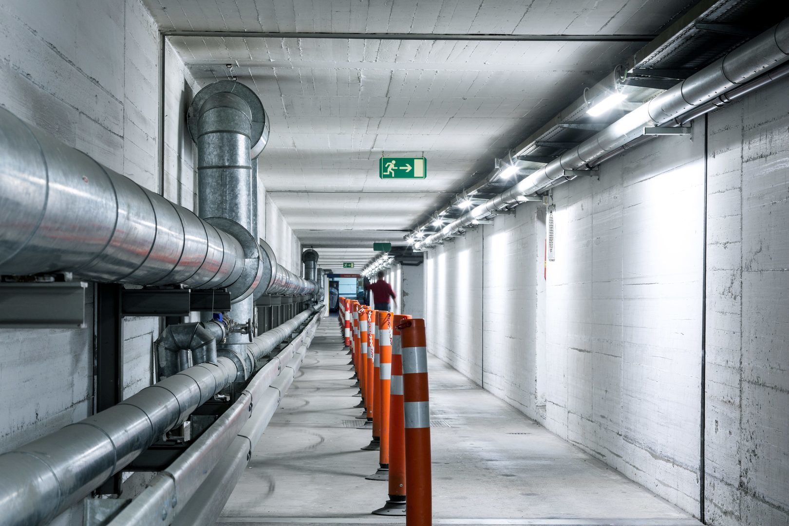 Lång betongkorridor upplyst av energieffektiva linjära takarmaturer från PROLJUS AB längs högra väggen som levererar jämnt klart vitt ljus för säkra och kostnadseffektiva industrimiljöer