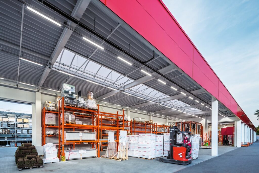 Modern lagerhall med högt tak upplyst av PROLJUS ABs linjära LED-armaturer som ger jämn, energieffektiv och arbetsvänlig belysning för industrilokaler och butiker