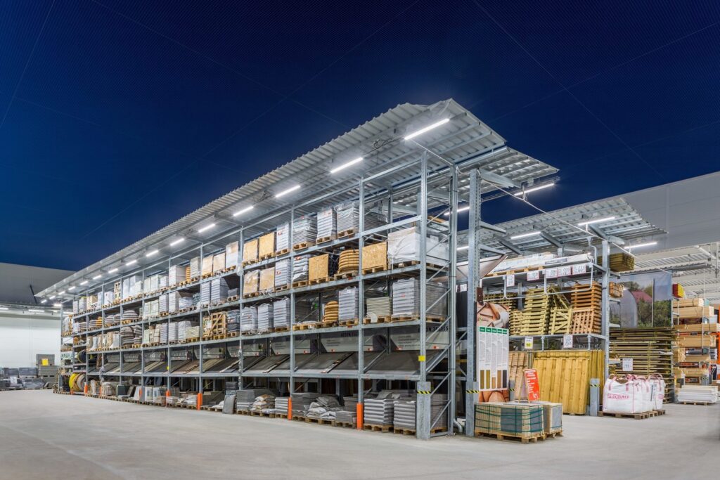 Stort industriellt lager med omfattande hyllsystem upplyst av moderna linjära LED-armaturer från PROLJUS AB som ger klart, jämnt och energieffektivt ljus som framhäver varor och minskar driftkostnader