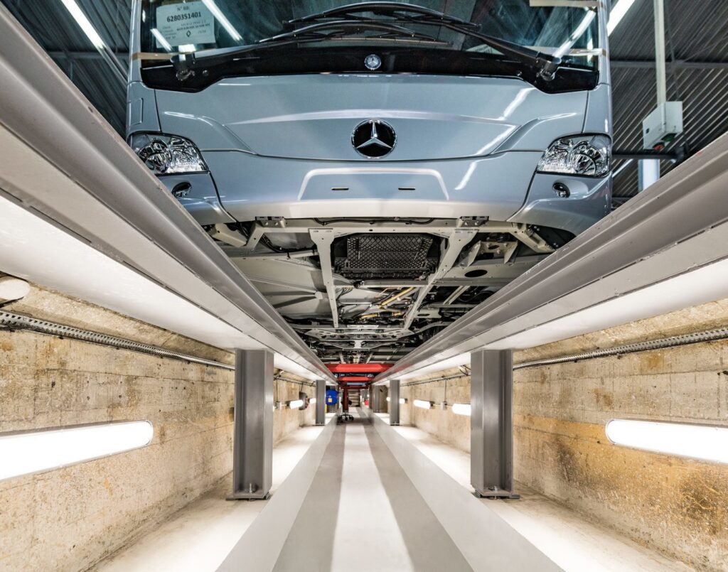 Inspektionsdike med fordons undersida belyst av parallella väggmonterade linjära LED-armaturer som skapar jämnt, bländfritt och energieffektivt arbetsljus, robusta industrilösningar perfekta för verkstäder och fordonsservice, finns hos PROLJUS AB