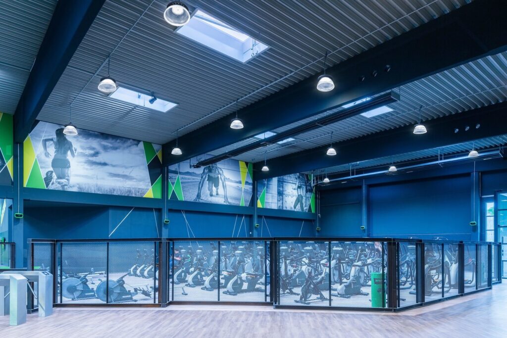 Högkvalitativa, energieffektiva hängande takarmaturer och infällda takljus i ett modernt gym som visar PROLJUS ABs LED-lösningar med jämnt, klart och behagligt ljus som framhäver ytor och sänker energikostnaderna