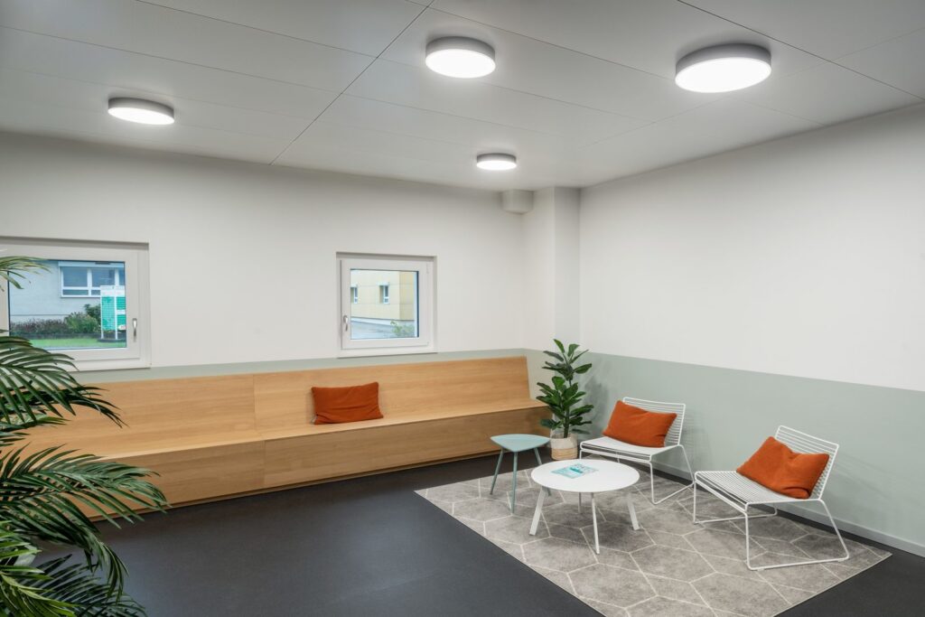 Väntrum med flera tunna cirkulära LED-takarmaturer som ger jämnt, bländfritt och energieffektivt ljus, modern skandinavisk design och enkel installation från PROLJUS AB