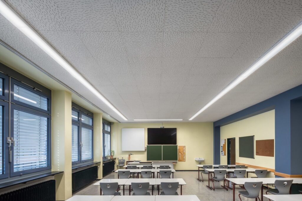 Modernt klassrum med två långa slimmade linjära LED-armaturer från PROLJUS AB monterade i undertaket, jämn bländfri belysning som förbättrar läsmiljön, minskar energikostnader och lyfter inredningen