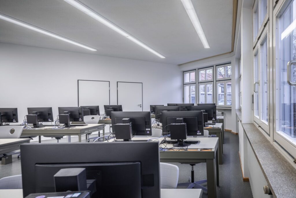 Modern datorsal belyst av långa tunna linjära LED-takarmaturer från PROLJUS AB som levererar jämnt bländfritt och energieffektivt ljus perfekt för skolor och kontor