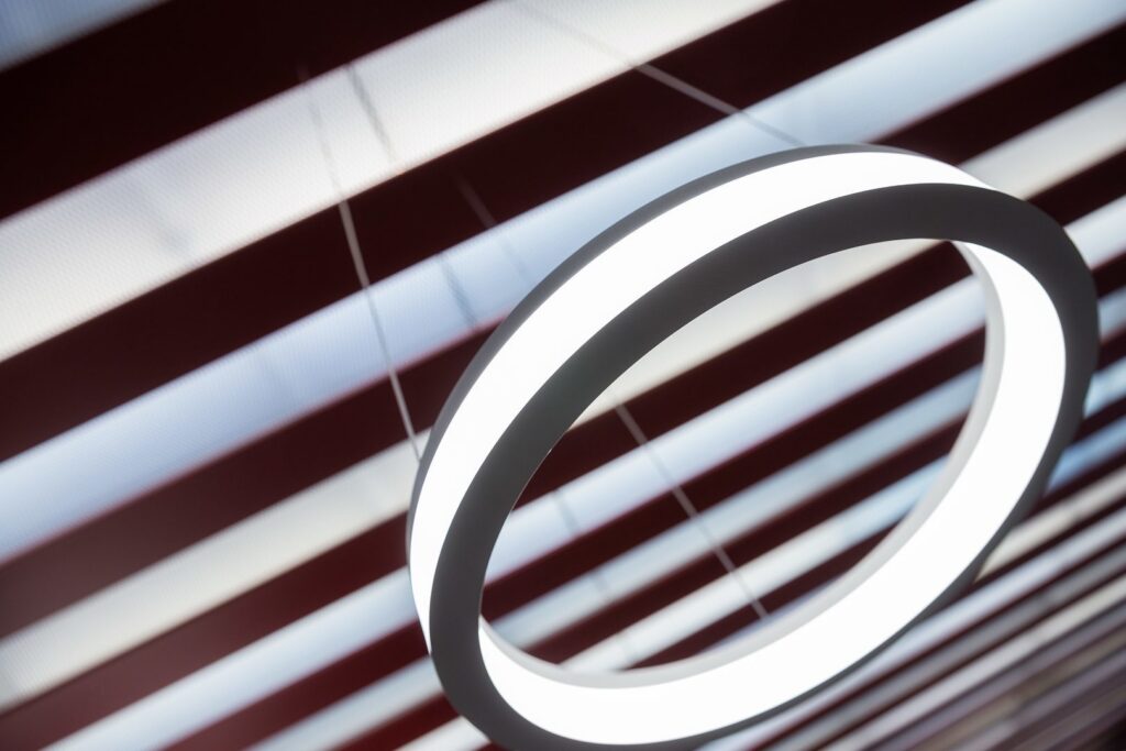 Modern cirkelformad LED-pendel med mjukt vitt ljus mot randigt innertak, elegant, energieffektiv och perfekt för kontor, butik eller hem från PROLJUS AB