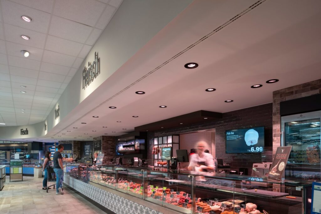 Modernt delikatess- och köttdisk i matbutik upplyst av infällda LED-downlights och spotlights som ger jämn, varm och energieffektiv belysning som framhäver varorna och ökar försäljningen från PROLJUS AB