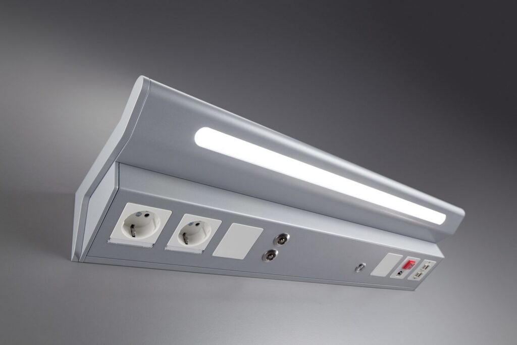 Snygg, slimmad LED-armatur från PROLJUS AB i silver med mjukt avbländat ljus, inbyggda eluttag, USB och anslutningar, energieffektiv och professionell lösning för kontor och vårdmiljöer