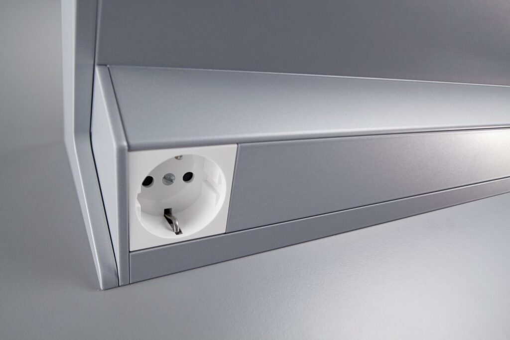 Modern silverarmatur i slimmat utförande med integrerat eluttag, högkvalitativ finish och praktisk funktionalitet från PROLJUS AB, perfekt för kontor och arbetsplatser