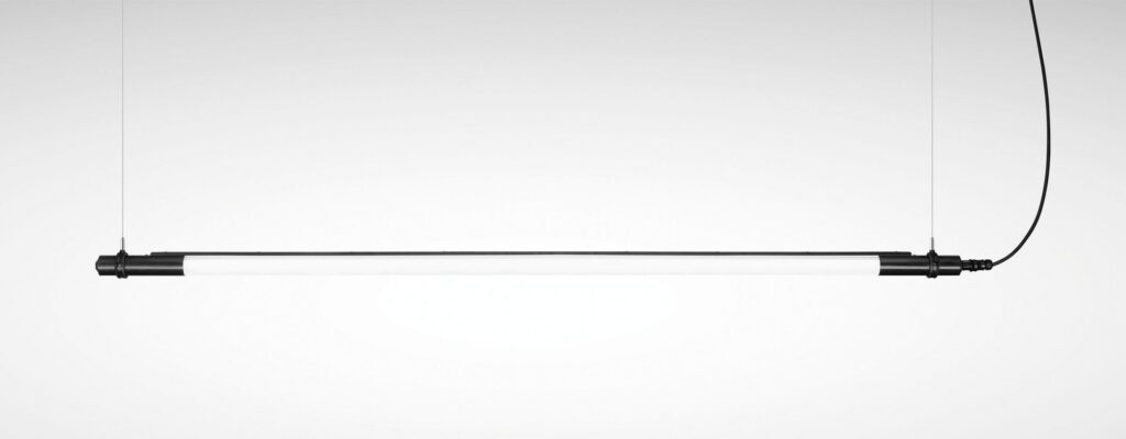 Svävande slimmad LED-armatur från PROLJUS AB med mattvit diffuser och svarta ändkapslar upphängd i tunna stållinor med strömkabel i ena änden energieffektiv och modern belysning idealisk för kontor verkstad och butik