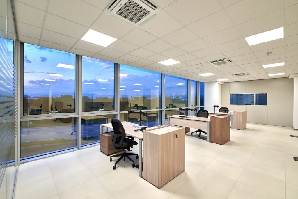 Kontorslandskap med jämnt fördelade infällda LED-paneler i undertaket som ger bländfri, energieffektiv och behaglig arbetsbelysning för ökad produktivitet, levererad av PROLJUS AB