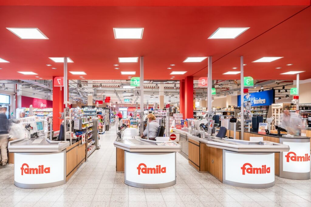 Infällda kvadratiska LED-armaturer i rött tak som ger jämnt, starkt och bländfritt butiksljus och framhäver varor och skyltning med energieffektiva belysningslösningar från PROLJUS AB