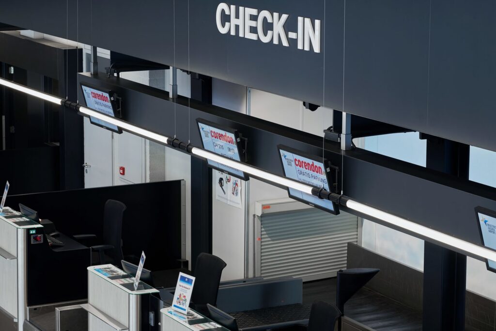 Fågelperspektiv över incheckningsdiskar belysta av långa upphängda LED-armaturer från PROLJUS AB som levererar jämnt energieffektivt vitt ljus, slimmad design och anpassningsbara lösningar för förbättrad synlighet och professionell atmosfär