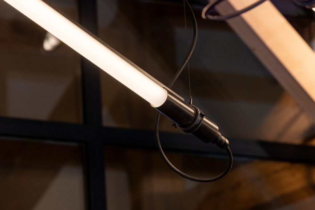 Hängande LED-rörlampa med varmvit diffust ljus och elegant svart montage, modern och robust design som förhöjer kontors‑ och butiksmiljöer, premiumarmatur från PROLJUS AB