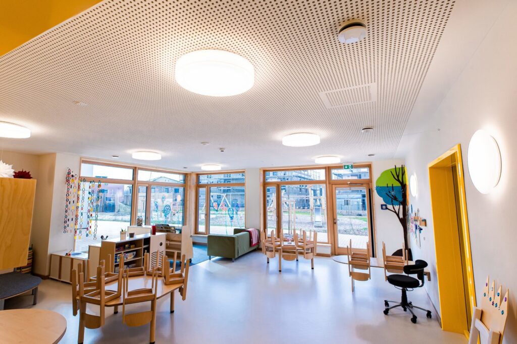 Interiör i en ljus förskolemiljö med stora runda takarmaturer och väggarmaturer som ger jämnt, bländfritt och energieffektivt LED-ljus, modern design och optimal arbetsbelysning från PROLJUS AB