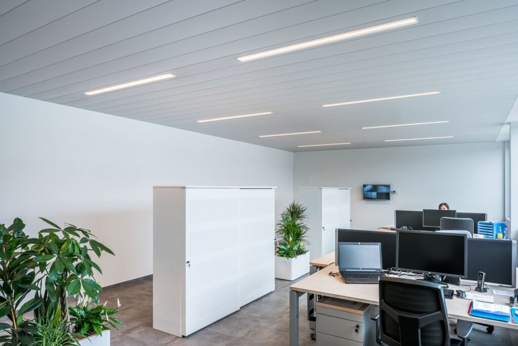 Öppet kontor med PROLJUS AB:s slimmade infällda LED-armaturer i taket som ger jämnt bländfritt arbetsljus, energieffektiv drift och modern design som höjer produktiviteten och värdet på arbetsmiljön