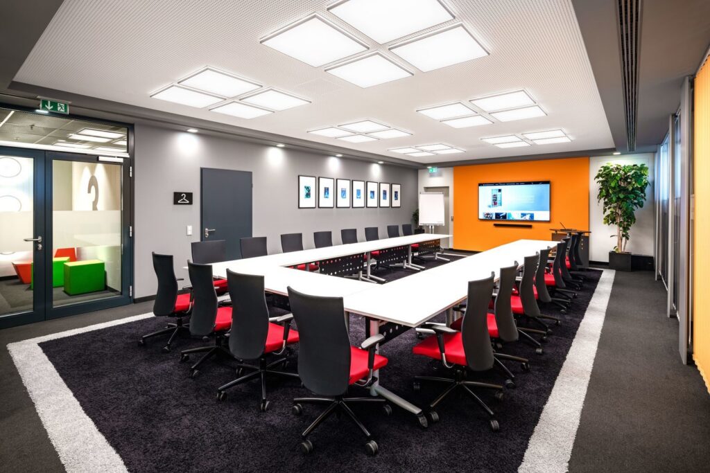 Konferensrum belyst av PROLJUS ABs kvadratiska LED-takarmaturer i gridmönster som ger jämnt, bländfritt och energieffektivt arbetsljus över hela bordet, en premiumlösning för företag som vill köpa och installera professionell belysning från PROLJUS AB