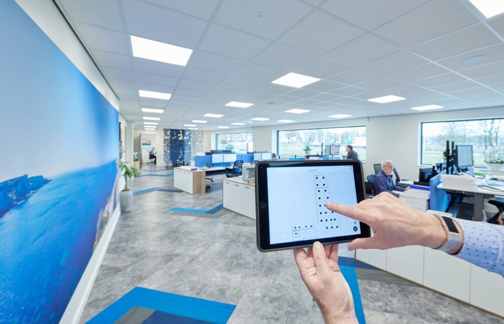 Öppet kontor med jämnt fördelade kvadratiska infällda LED-armaturer i undertaket som ger klar, energieffektiv arbetsbelysning och modern estetik, en idealisk belysningslösning från PROLJUS AB för ökad produktivitet och lägre energikostnader