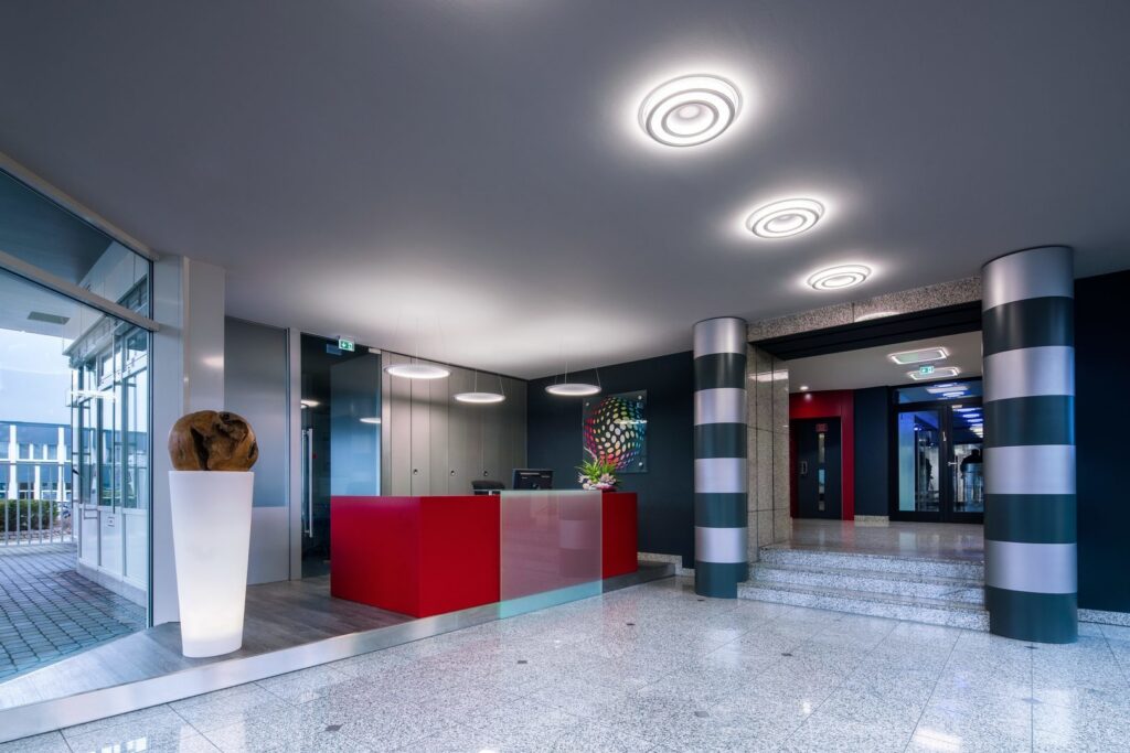 Modern entré med eleganta cirkulära takarmaturer och hängande ringlampor från PROLJUS AB, energieffektiva LED-armaturer som skapar jämn, varm belysning och lyfter designen i receptioner och kontor